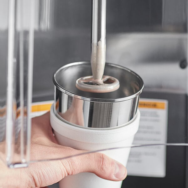 A hand using a stainless steel malt cup collar on a metal malt cup.
