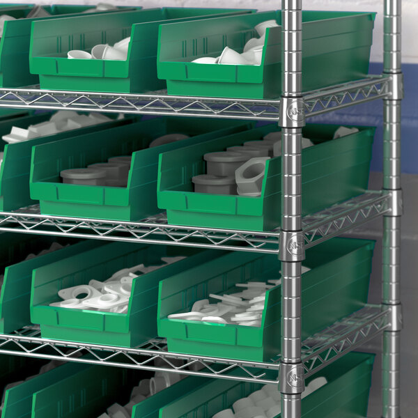A metal shelf with a green Regency shelf bin containing white cups.