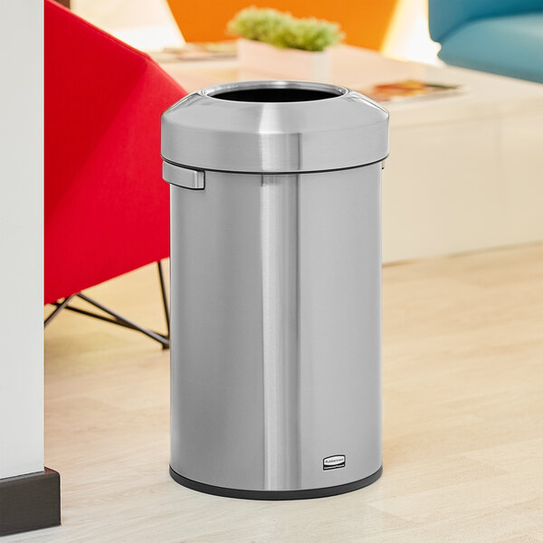 A Rubbermaid stainless steel trash can on a wood floor.