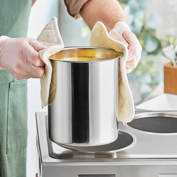 A person holding a Choice stainless steel bain marie pot with a towel over it.