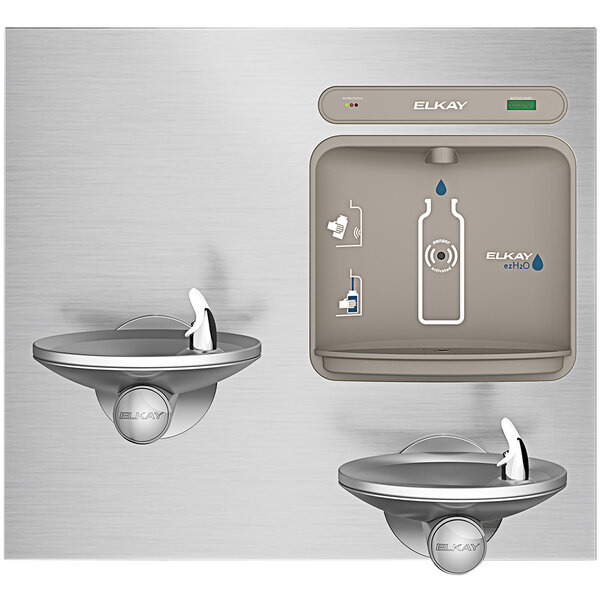 An Elkay stainless steel water dispenser with two faucets over a water fountain.