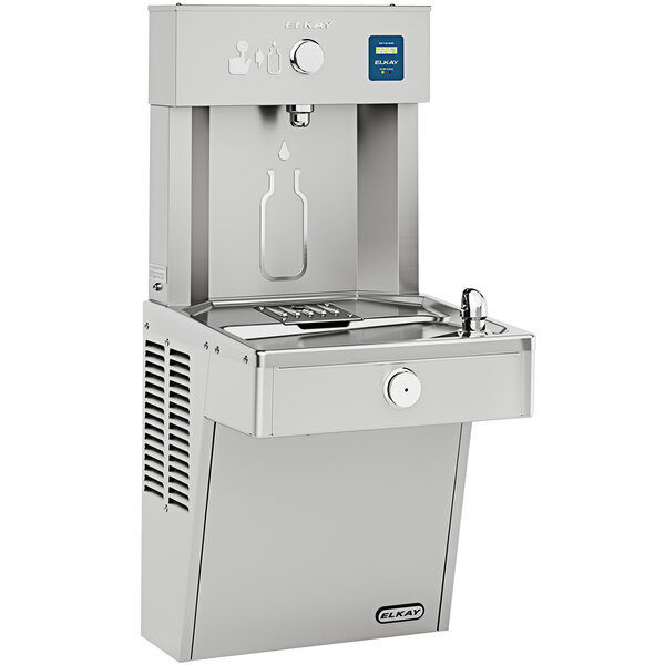 An Elkay stainless steel water fountain with a bottle filling station on the top.