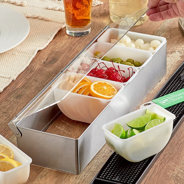 A Tablecraft stainless steel condiment bar with 6 containers of fruit and limes.