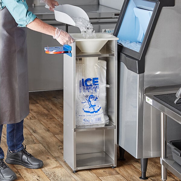 A man wearing an apron using the Choice Ice Bagger Kit to bag ice on a counter.