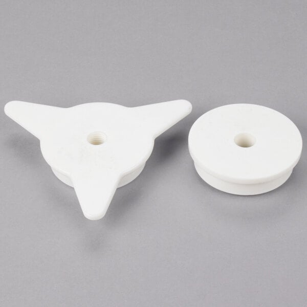 Two white plastic circular adapters with a hole.