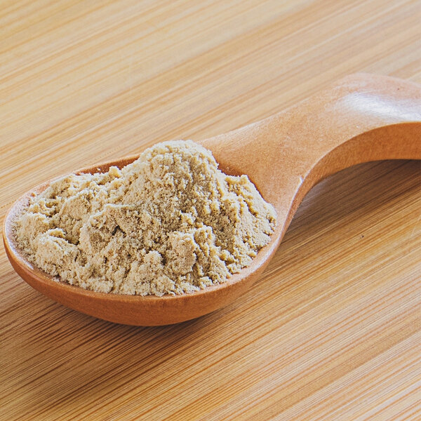 A wooden spoon full of plum powder.