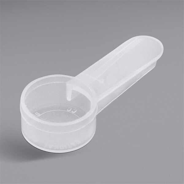 A white plastic measuring spoon with a handle.