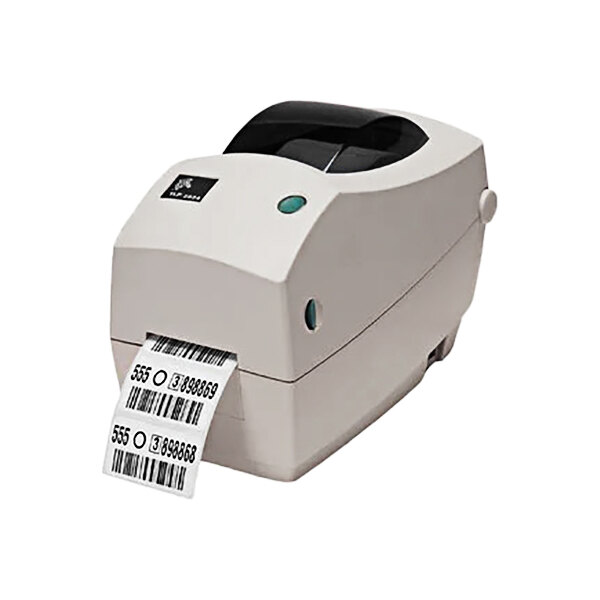 A white Zebra TLP2824 barcode printer printing a black barcode label.
