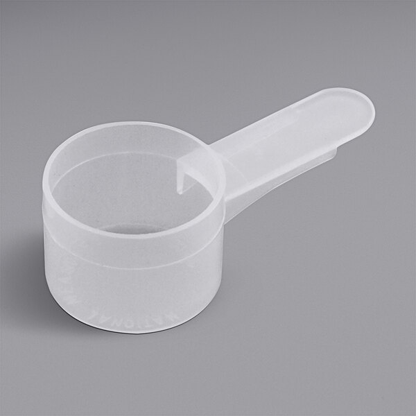 A white plastic measuring scoop with a handle.