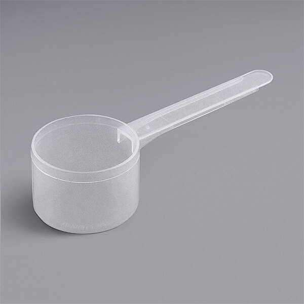 A clear plastic measuring scoop with a long handle.