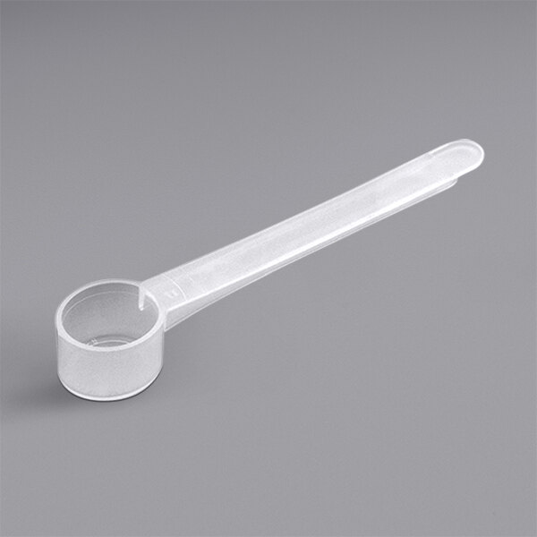 A white plastic measuring scoop with a handle.