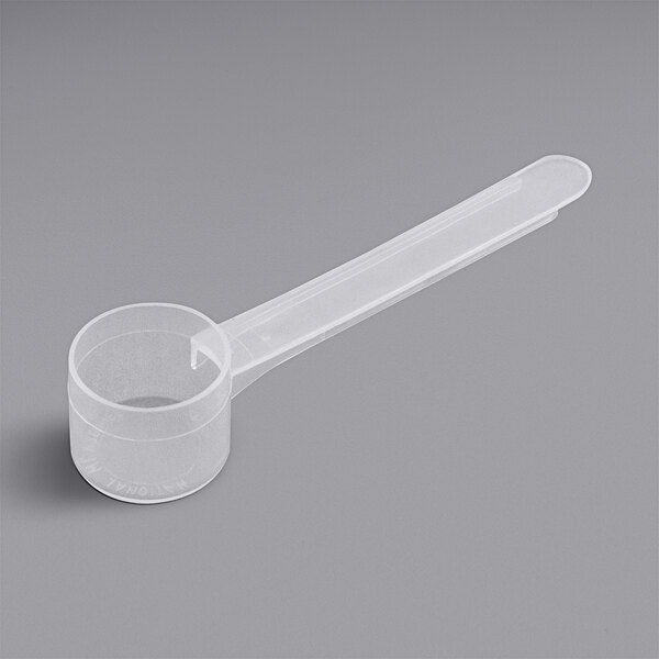 A clear plastic measuring spoon with a long handle.