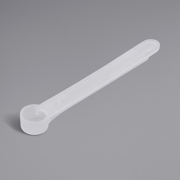 A white plastic measuring spoon with a long handle.