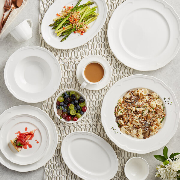A white table with Acopa Condesa porcelain saucers and bowls on it.