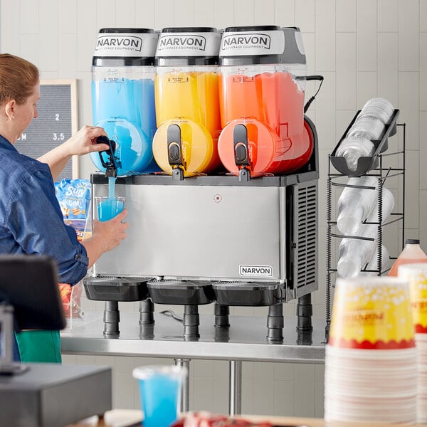 A woman pouring a blue drink into a Narvon granita machine.