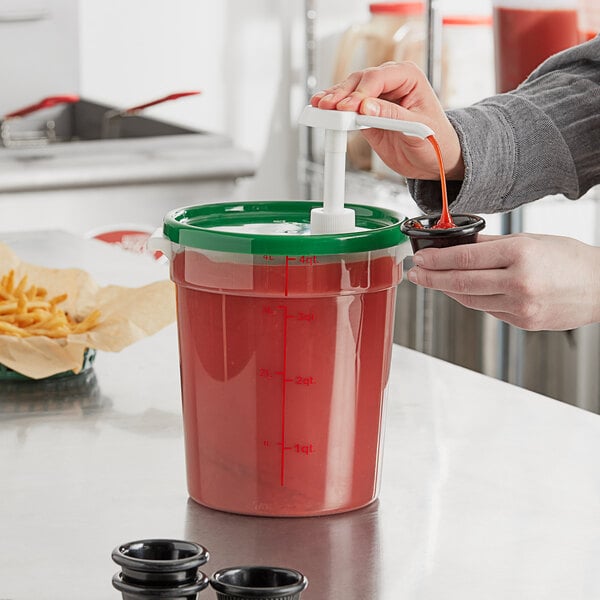 A woman using a Choice condiment pump to pour red liquid into a container.