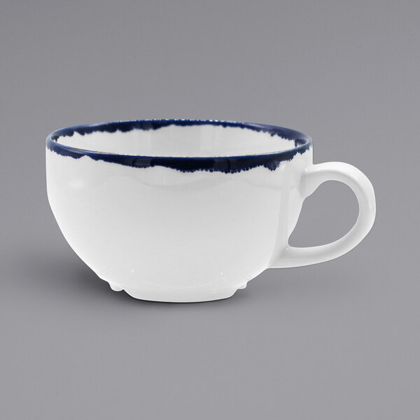A white china teacup with a blue rim.
