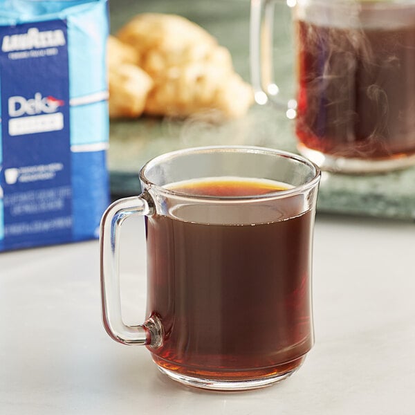 A glass mug of Lavazza Dek Filtro Decaf coffee with brown liquid on a white background.