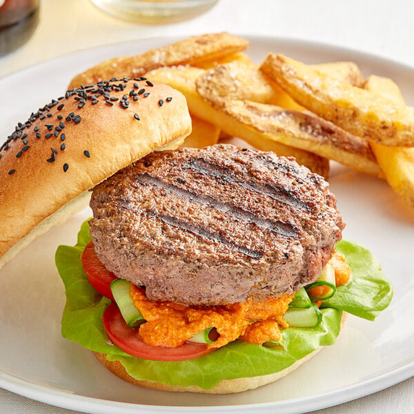 A Rastelli's American Wagyu burger with lettuce and tomato on a plate with fries.