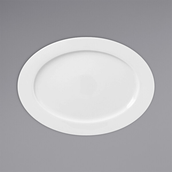 A white oval porcelain plate with a wide rim on a gray surface.