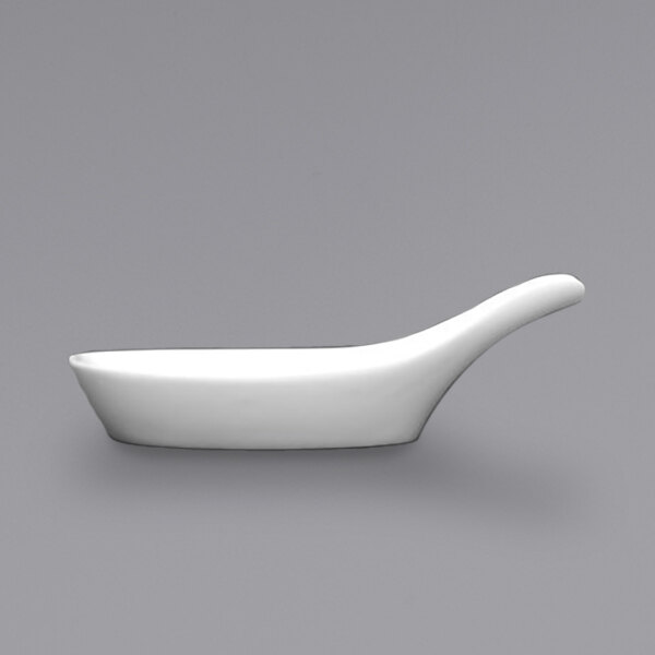 A white Fortessa porcelain spoon rest with a spoon in it.