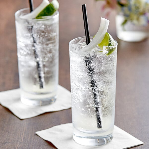 Two glasses of Tractor Beverage Co. Organic Coconut Soda with ice and lime slices.