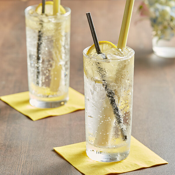 Two glasses of Tractor Beverage Co. Organic Lemongrass soda with straws and lemon slices.