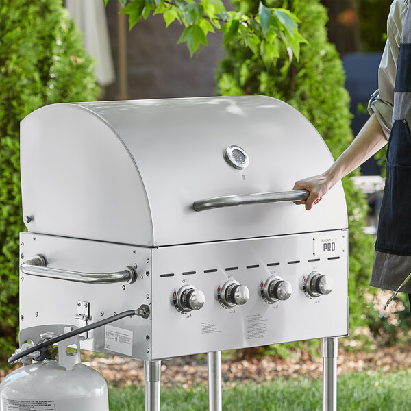 A woman holding a Backyard Pro Roll Dome lid for a grill.
