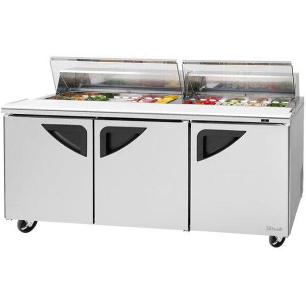 A Turbo Air refrigerated sandwich prep table with clear lids over three doors.