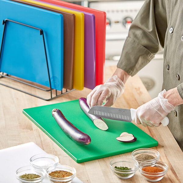 A person cutting eggplant on a Choice polyethylene cutting board.