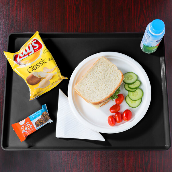 A black Cambro dietary tray with a sandwich, vegetables, and a drink on it.