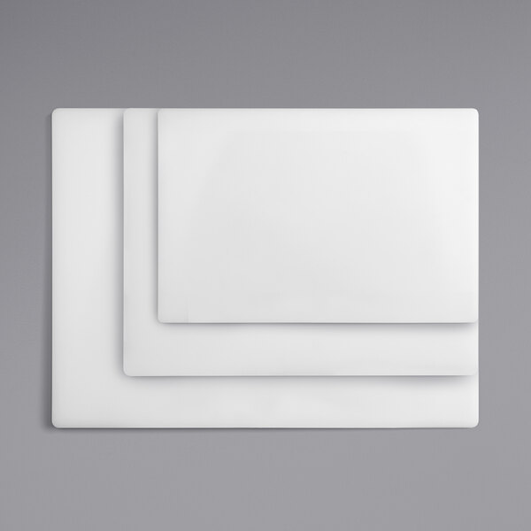 A stack of three white rectangular Choice polyethylene cutting boards.