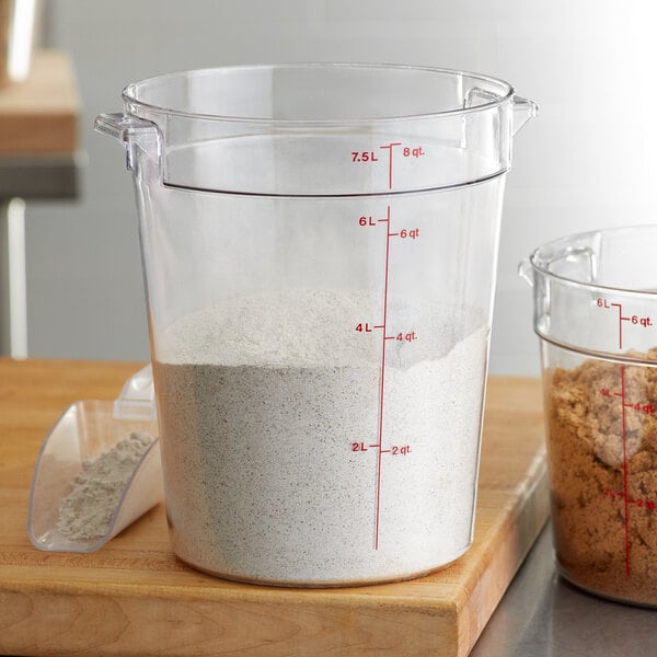 A measuring cup filled with white powder in a Cambro food storage container.