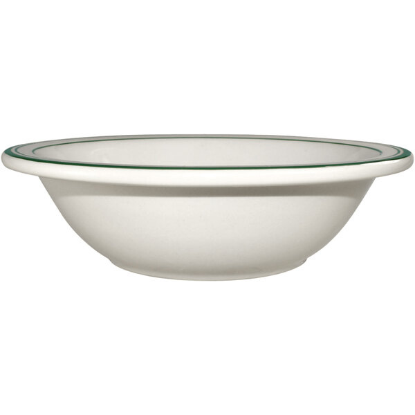 An ivory stoneware grapefruit bowl with green bands on the rim.