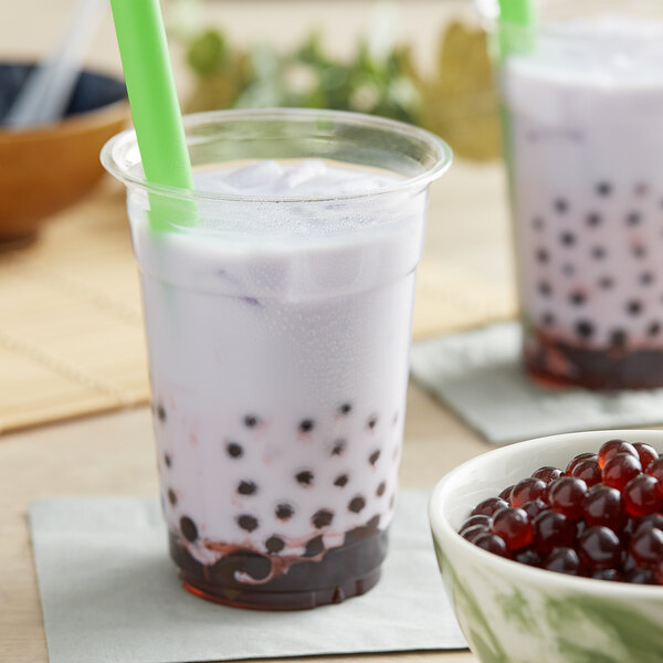 A cup of bubble tea with a green straw and Fanale Blueberry Popping Boba.