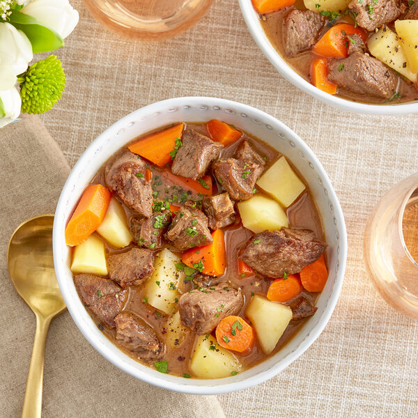 A bowl of venison stew with carrots and potatoes.