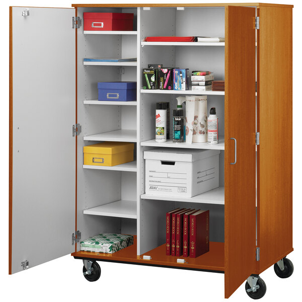 A light oak I.D. Systems storage cart with shelves and objects on wheels.