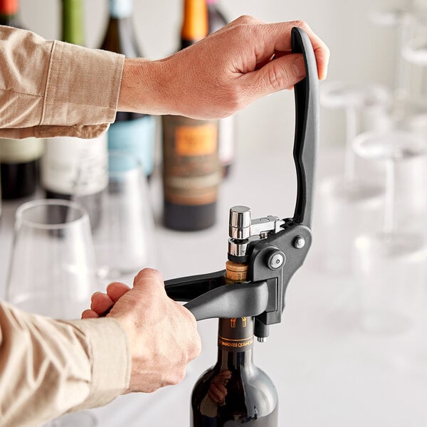 A person using the Franmara VinoPull corkscrew to open a bottle of wine.