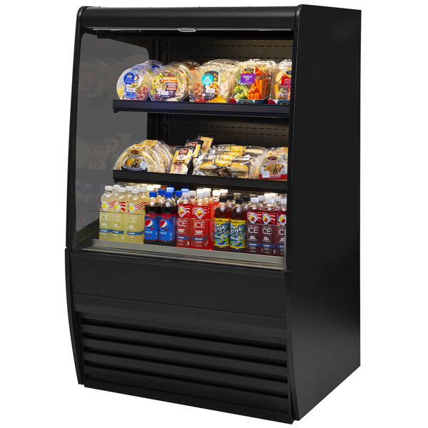 A black Federal Industries refrigerated display case with food on shelves.