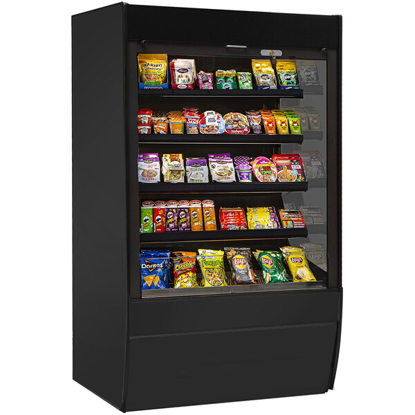 A black Federal Industries Vision Series non-refrigerated display case with different types of snacks on shelves.