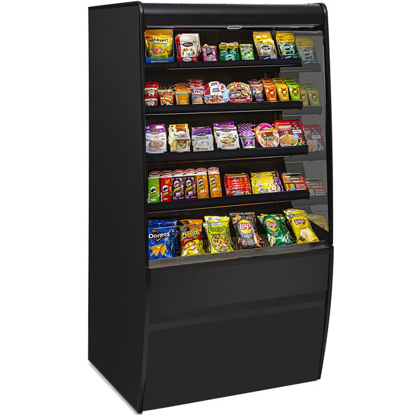 A Federal Industries Vision Series curved high profile non-refrigerated display case with food on shelves.