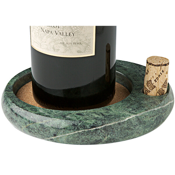 A bottle of wine in a Franmara green marble wine coaster.