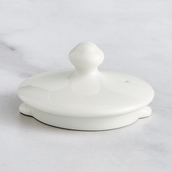 A white round lid with a small knob on top.