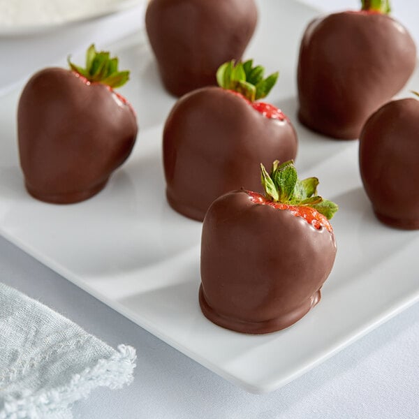 Chocolate covered strawberries on a white plate with Van Leer Milk Confectionary Coating.