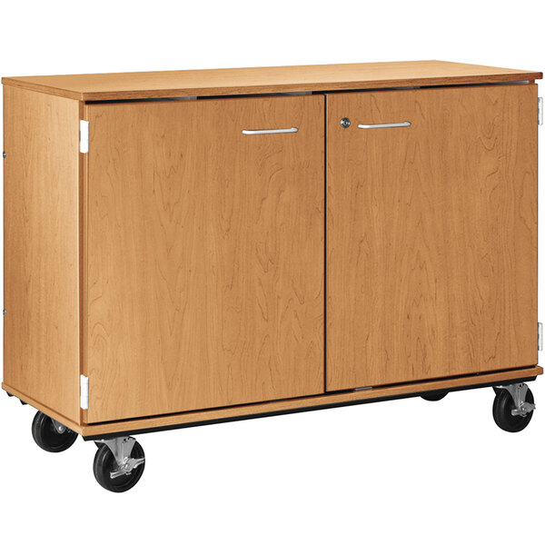A wooden I.D. Systems folio storage cabinet with locking doors on wheels.