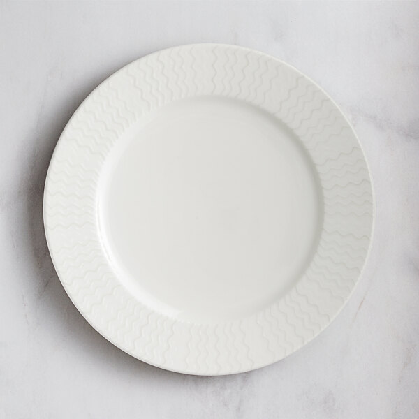 A RAK Porcelain Leon ivory porcelain plate with wavy lines on the rim.
