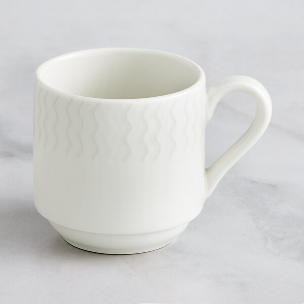 A white RAK Porcelain stackable coffee cup with an embossed wavy design and handle.