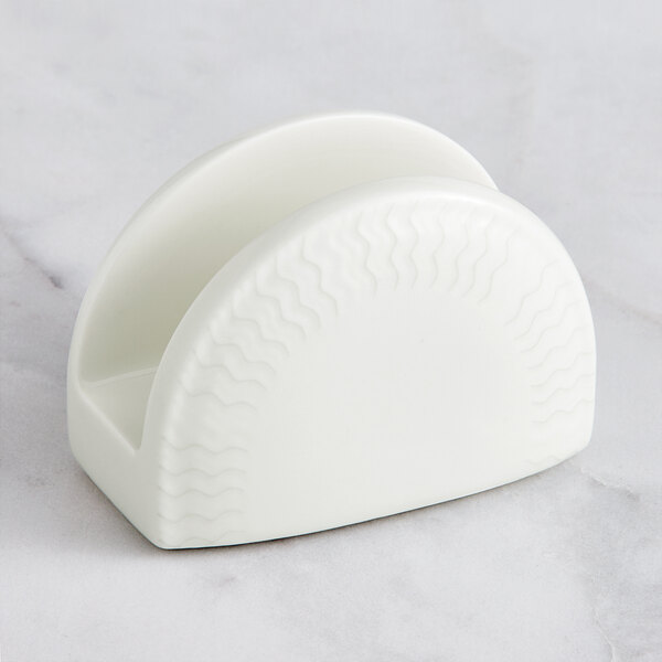 A white porcelain napkin holder with wavy lines.