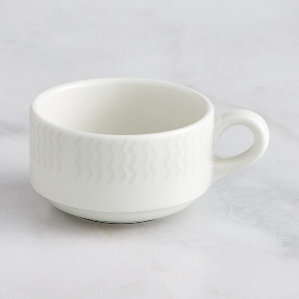 A close up of a RAK Porcelain Leon ivory stackable cup with a handle.