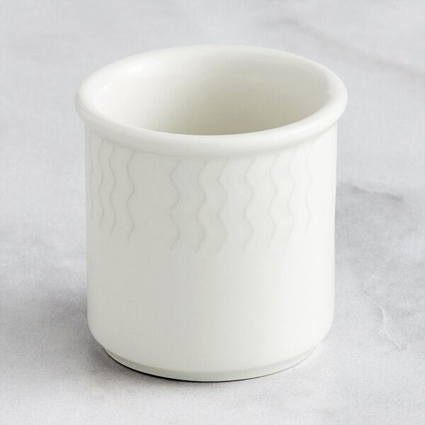 A white porcelain toothpick holder with a wavy pattern.